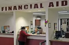 woman talking with financial aid official over counter
