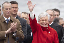 governor Kay Ivey waving with group of people behind her